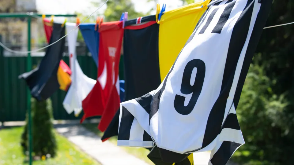 Camisola de futebol com emblema, estampa e patches a ser lavada